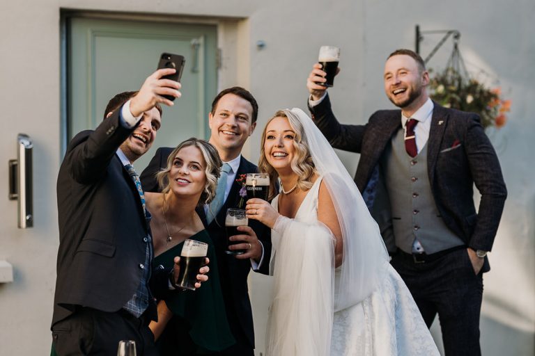 bride, from and friends taking a selfie all with pints of Guinness.