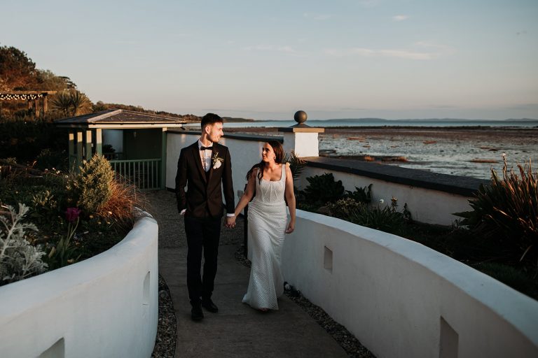 bride and groom walking together at The Orange Tree house, Northern Ireland in golden light.