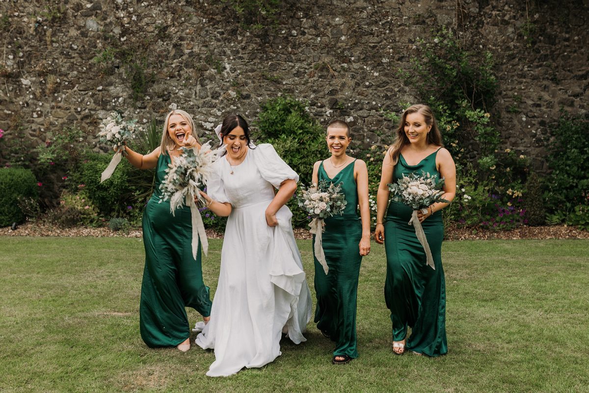 bride with her bridesmaids walking towards the camera having fun together