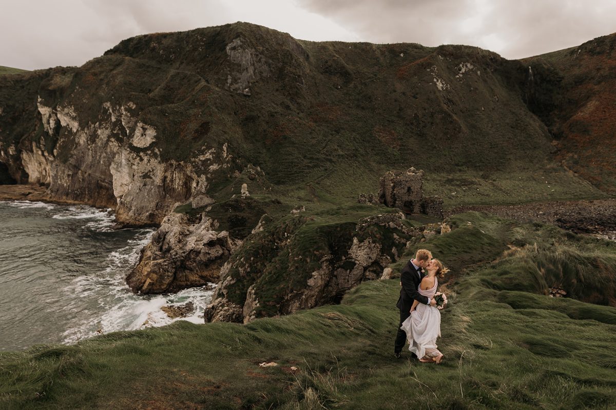 eloping couple on cliff edge at Kinbane castle Ireland