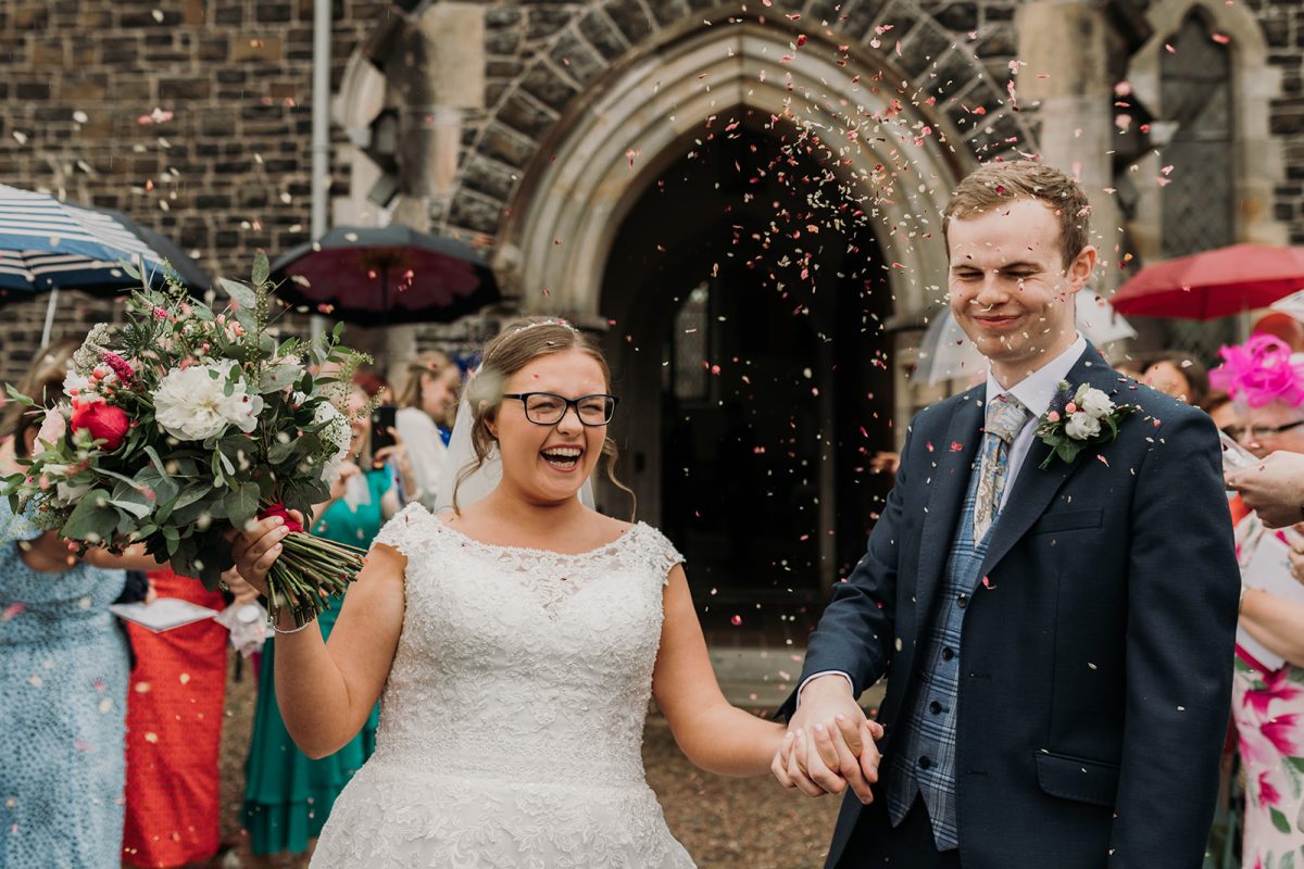 couple just married at church. couple walking through confetti