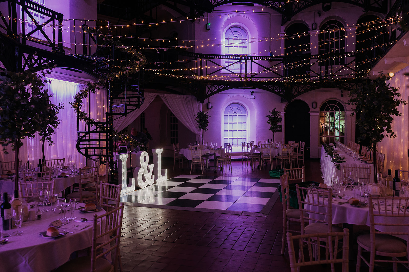 reeption room ready at Crumlin road Gaol Belfast. Showing light up letters, chequered board dancefloor and purple lights inside the old jail.