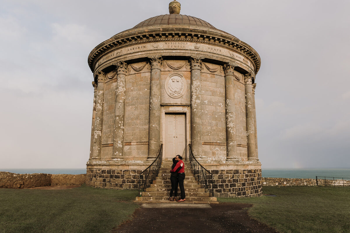 couple standing outside of Mussenden temple who just got engaged