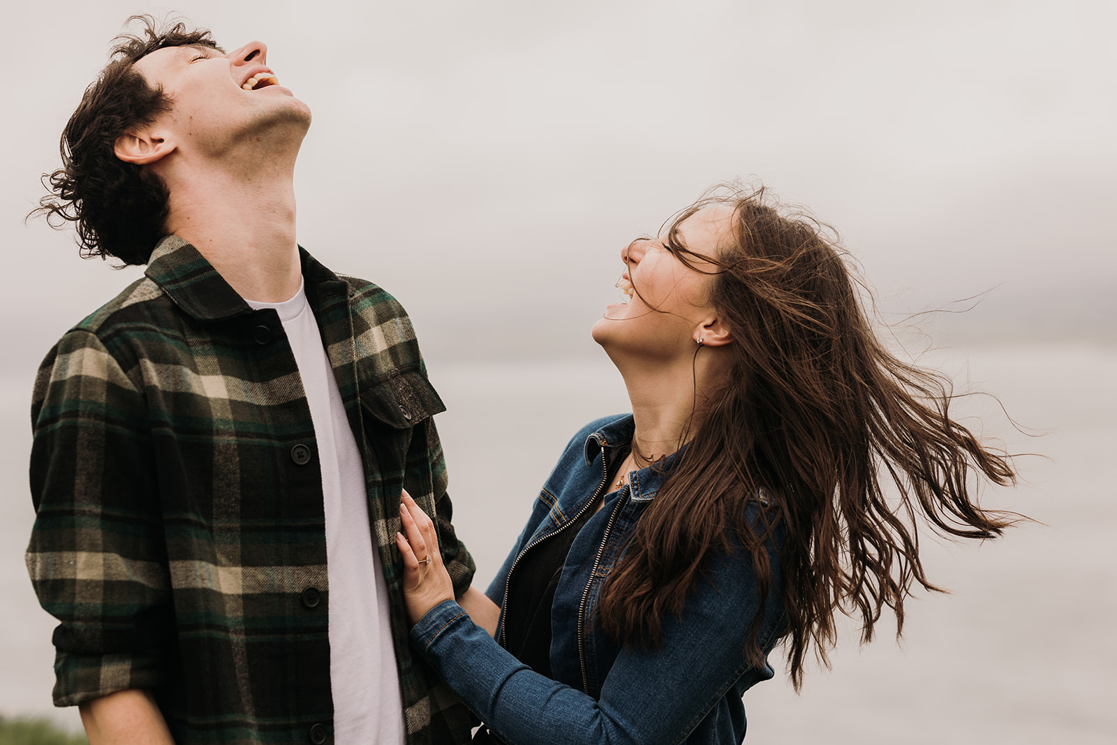 couple embracing the wind by the northern ireland coast.